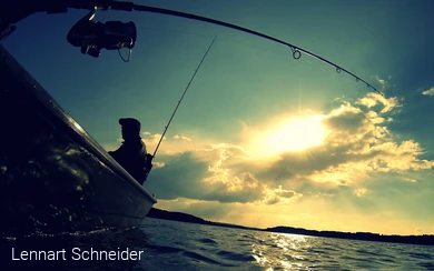 Silhouette einer Person beim Angeln vom Boot bei dramatischem Gegenlicht.