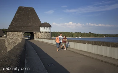 Junge Erwachsene wandern über die Staumauer