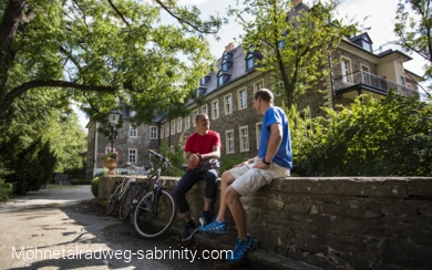 Radfahrer pausierend vor Unterkunft