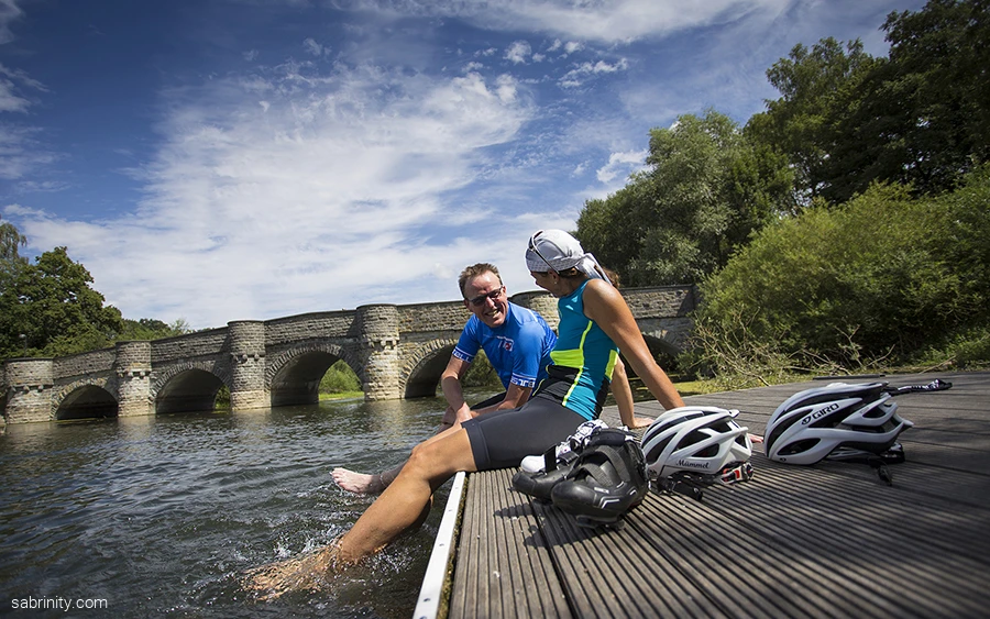 Radfahrer plantschen im Wasser Kanzelbrücke Möhnesee (2).jpg Radfahrende kühlen ihre Füße im Wasser ab