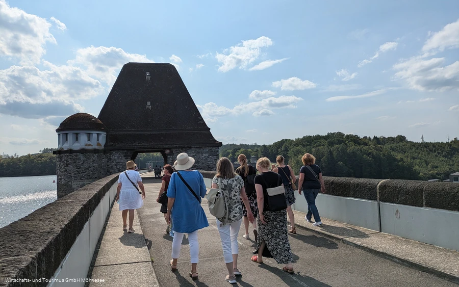Gruppenführung Staumauer 03 Gruppe von Personen spaziert über die Staumauer des Möhnesees.
