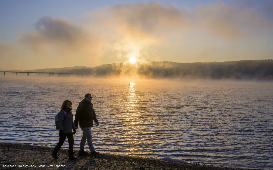 Wanderer am Möhnesee bei Sonnenaufgang