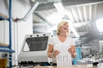 Mitarbeiterin an einem Druckerei-Arbeitsplatz